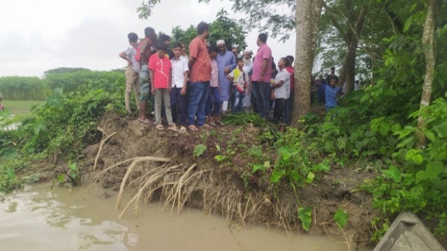 Locals gaze across the Arial Khan River, remembering the land and homes lost to erosion — a scene all too common for hundreds of families now displaced in Madaripur’s Kalkini Upazila.