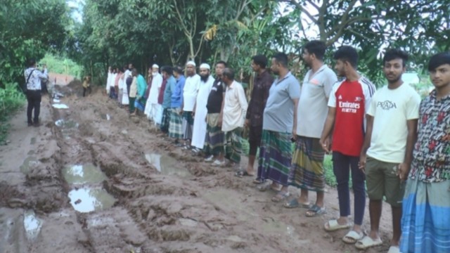 Residents of Uttar Pachkhola in Madaripur Sadar Upazila walk along a severely damaged village road, demanding urgent repairs after years of neglect. The one-kilometer stretch has become nearly impassable, posing daily risks to commuters. Photo: V7N
