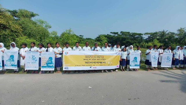 Environmental activists form a human chain on Rudra Muhammad Shahidullah Road in Mongla on Thursday, demanding climate reparations and debt cancellation ahead of the World Bank–IMF annual meetings.