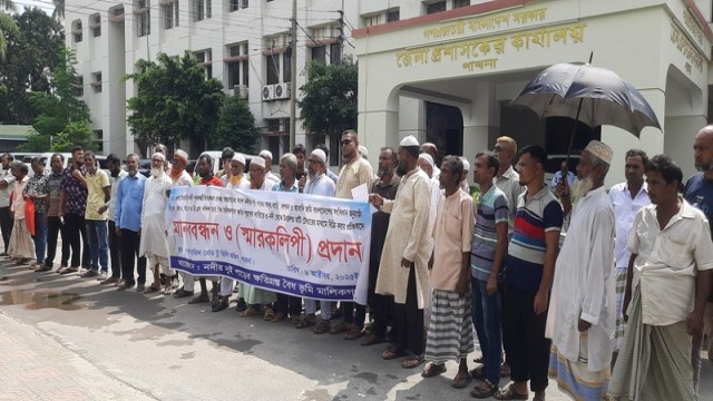 Farmers and landowners form a human chain in front of the Pabna Deputy Commissioner’s Office on Monday, demanding compensation for damages caused by the Ichamati River dredging project. (Voice7 News Photo)