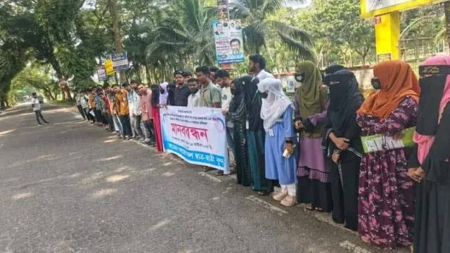 Students and local residents forming a human chain and blocking the road in Jhalokathi to demand renaming Basunda College to reflect the district’s name.