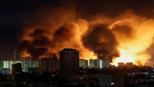 Residents of Kyiv react as air raid sirens wail and anti-aircraft fire lights up the sky during a large-scale Russian drone and missile attack, causing widespread damage to buildings and infrastructure.