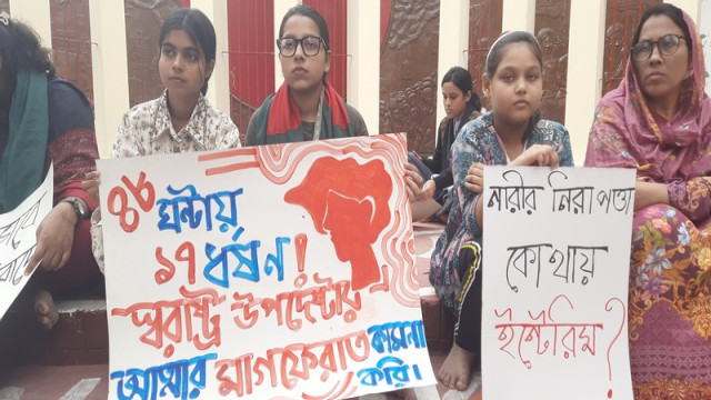 Protesters in Tangail hold placards praying for the soul of the Home Affairs Advisor during a rally for justice.