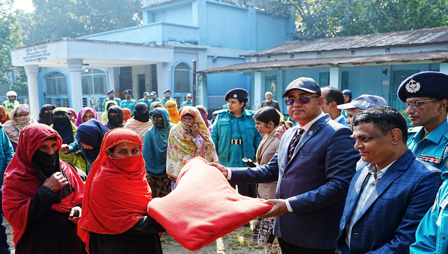 RMP Police Commissioner Mohammad Abu Sufian distributing winter clothes among the needy at the Jamira High School ground in Belpukur, Rajshahi.