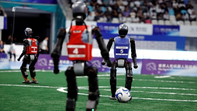 Humanoid robots clash during a lively football match at the World Humanoid Robot Games in Beijing, showcasing cutting-edge AI and robotics innovations.