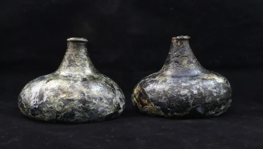 Divers recover two rare onion glass bottles from the 1715 Treasure Fleet shipwreck, preserved for over 300 years on the Atlantic Ocean floor.