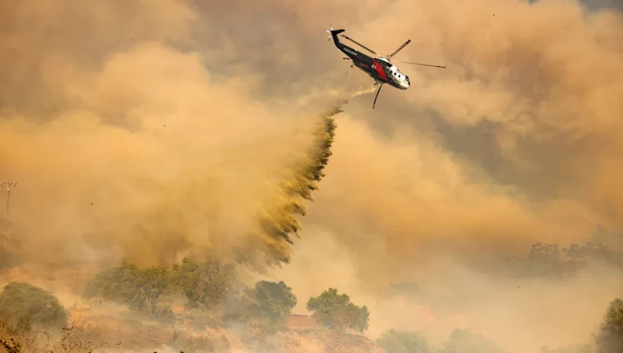 Helicopters are deployed to drop water and retardant on the Mountain Fire in Ventura County, as crews work to control the blaze that has scorched over 20,000 acres.