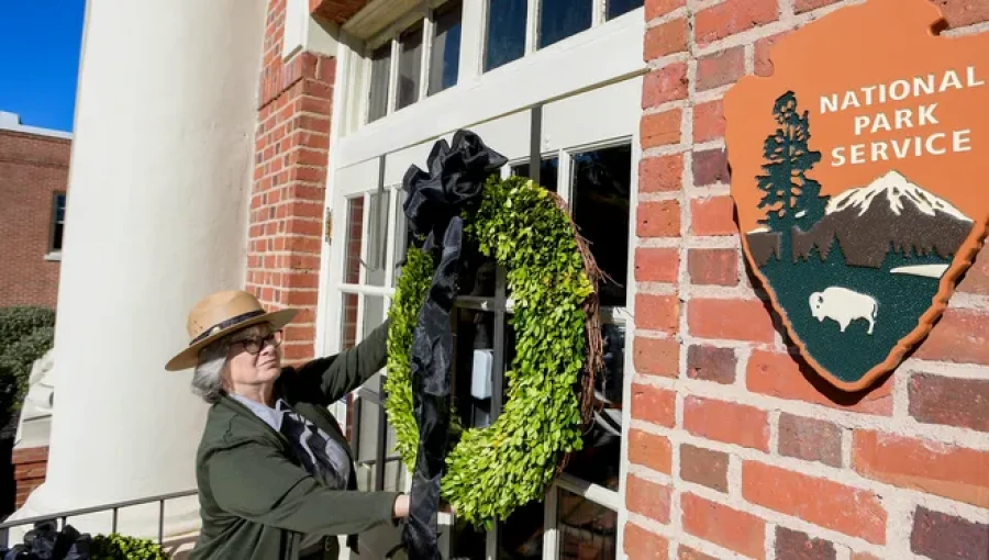 A wreath is placed at Plains High School, now a visitor's center dedicated to President Jimmy Carter, as locals and visitors honor the late president’s legacy following his passing at the age of 100.