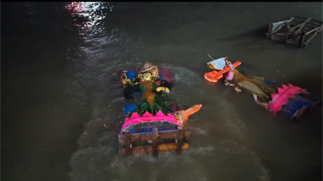 Devotees carry the central Durga idol of Bottola Mandir to the ferry ghat before immersing it in the Mongla River under tight security by the Navy and Coast Guard.