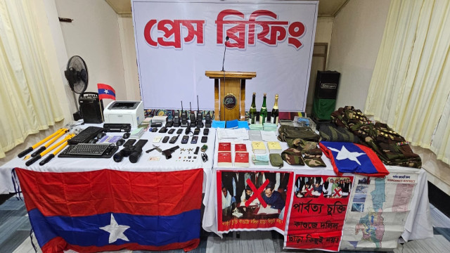 Army personnel display weapons and equipment seized from a UPDF hideout during a recent operation in Rangamati.