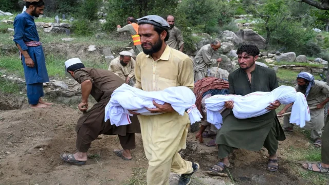 A grieving relative carries the body of a child wrapped in a burial shroud following the devastating earthquake in southeastern Afghanistan. The disaster has claimed over 1,400 lives, with children among the worst affected. Photo: Reuters