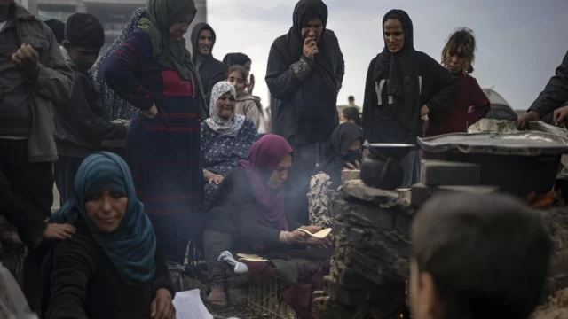 Palestinians displaced by the Israeli bombardment wait for their turn to bake bread at the makeshift tent camp in the Muwasi area in Rafah, Gaza Strip, Saturday, Dec. 23, 2023. (AP Photo/Fatima Shbair