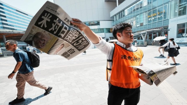 People read a special edition of the Yomiuri Shimbun newspaper reporting the U.S.-Japan trade deal, Tokyo, July 23, 2025.