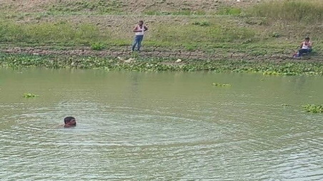 "Union Sramik League leader Nayeb Ali in the Gumani River at Bishwanathpur village, Chatmohar, Pabna."