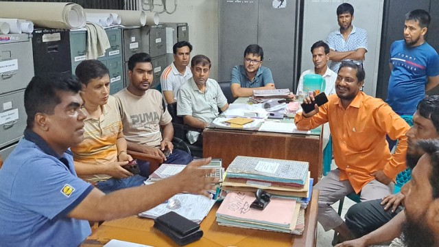 Chatmohar Police Station Officer-in-Charge Manjurul Alam speaks to farmers inside the Pabna Rural Electrification Society-1 office, assuring them of prompt action following the transformer theft.