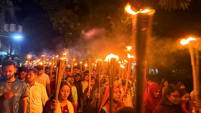 CUET students march with torches during a campus rally protesting police violence and threats against fellow engineering students, held in Chattogram on Friday night.