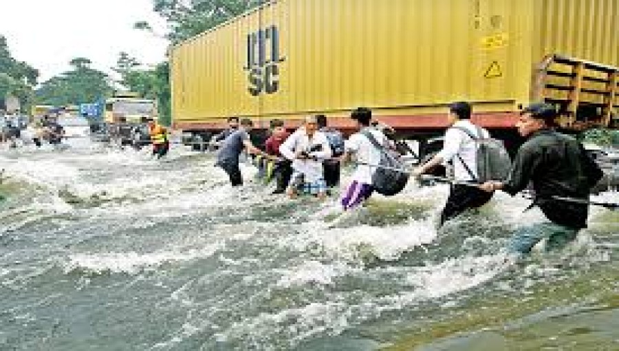 Volunteers navigate through submerged roads in Cumilla district, struggling to deliver relief supplies to flood-affected residents.