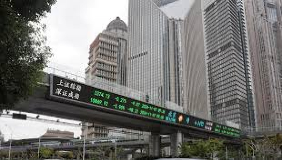 Cars pass by a pedestrian overpass displaying stock information in the Lujiazui financial district of Shanghai, China.