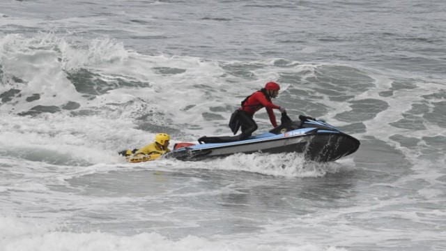 Rescue teams conducting operations off the San Diego coast following a tragic boat capsizing incident. At least three people have died, and seven remain missing.