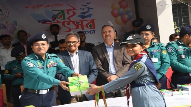 At Rajarbagh Police Lines School and College, DMP Commissioner Habibur Rahman distributes textbooks