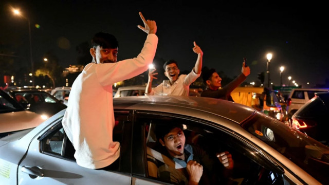 Fans celebrate near India Gate in New Delhi Sunday after India won the Champions Trophy final against New Zealand in Dubai Photo: AFP