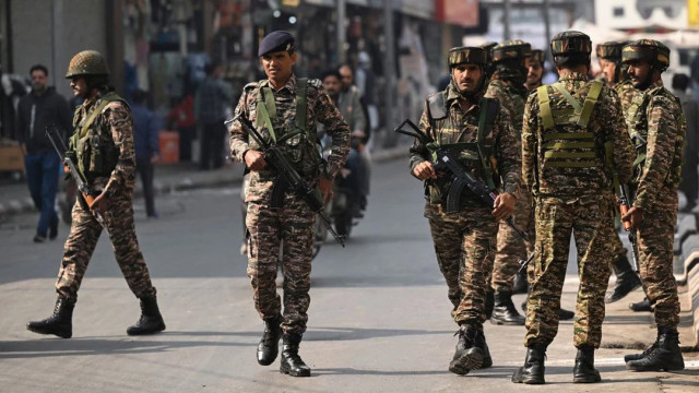 File image: Indian security personnel watch over as they guard along a road in Srinagar