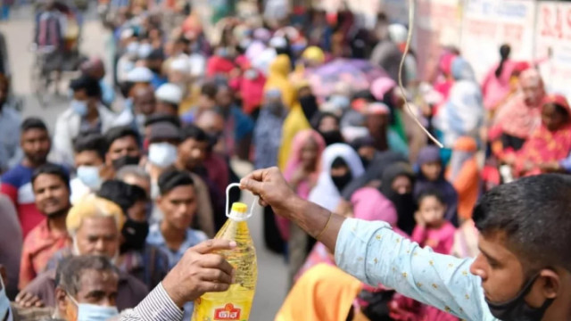 The photo shows people waiting in line to buy products from a mobile truck of the Trading Corporation of Bangladesh (TCB).