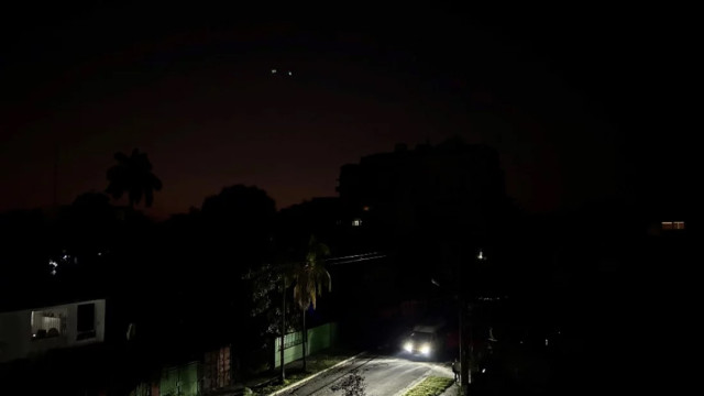 Car lights illuminate a street during a general blackout in Havana on March 14, 2025. Photo: AFP