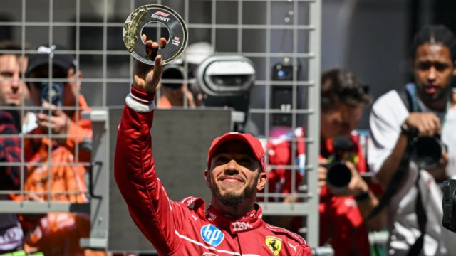 Ferrari's British driver Lewis Hamilton holds up the trophy as he celebrates winning Saturday’s sprint race of the Chinese Grand Prix at Shanghai International Circuit Photo: AFP