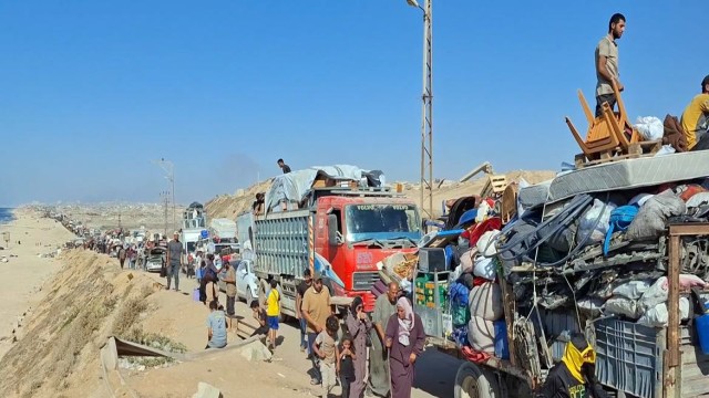 Hundreds of Palestinian families flee Gaza City along the congested Al Rashid Road, facing severe transport shortages and skyrocketing travel costs amid ongoing conflict.