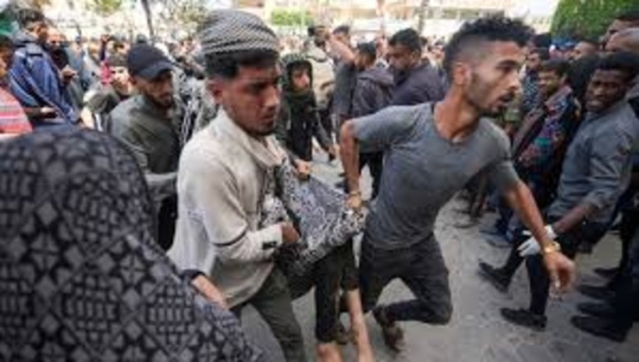 Rescue worker carries a wounded from the rubble after an Israeli air strike in Gaza City on Thursday. Photo: Collected