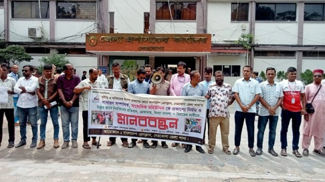 Journalists and activists form a human chain in front of the Netrokona District Commissioner’s office on Sunday, protesting the attack on journalist Mohiuddin and demanding justice.