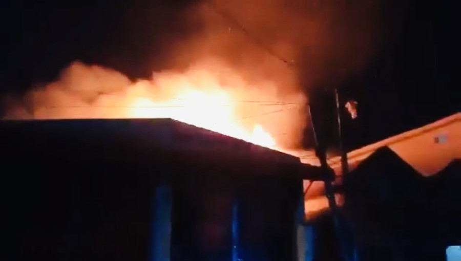 "Firefighters work to control a blaze at a jute sack warehouse in Khulna's Barabazar area, as smoke rises from damaged shops and goods."