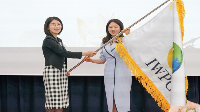 The IWPG flag is ceremoniously handed over to the new chairwoman, Jeon Na Yeong, marking a new chapter in the organization’s leadership. Photo: IWPG