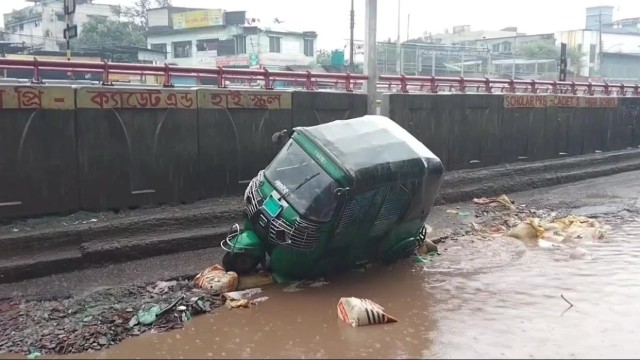 A CNG auto-rickshaw lies in a roadside ditch on the Jatrabari-Mawa Highway in Dhaka South, where dangerously damaged road conditions continue to put daily commuters at serious risk.