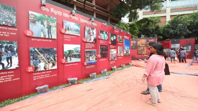 Visitors observe large canvas displays at Dhaka University TSC, part of a student-organized exhibition highlighting alleged state repression and political violence over the past 16 years.
