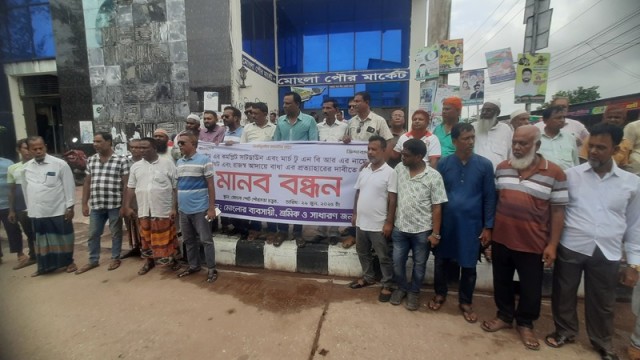 Local traders and workers form a human chain in front of Mongla Municipal Market on Sunday, protesting the complete shutdown of Mongla Customs House and demanding immediate withdrawal of the strike disrupting national revenue collection.