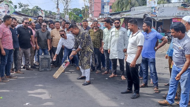 BNP leader Kazi Khairuzzaman Shipon plays cricket on a street in Morelganj during the second day of the 48-hour hartal in Bagerhat.
