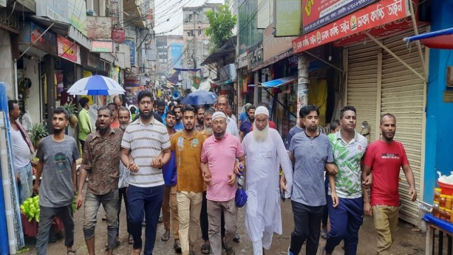 Traders protest against harassment in the name of fines at Boro Bazar, Pabna town, on Monday afternoon. (Photo: V7N)