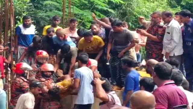 Fire service personnel recover the bodies of two workers from the scene on Thursday morning in the Dakshinpara area of Bera municipality, Pabna. Photo: V7N