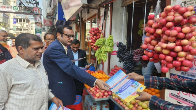 ACC officials and Anti-Corruption Prevention Committee members distribute flyers for the public hearing on Wednesday afternoon on Abdul Hamid Road, Pabna.