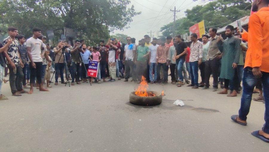 "Workers protested against the case filed against the Upazila Chairman and demanded the removal of the OC by burning tires and blocking roads. On Sunday morning in Pabna's Atghoria Bazar." Photo: Voice7 News