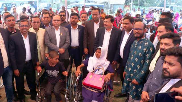 BNP Chairperson's Special Assistant Advocate Shamsur Rahman Shimul Biswas distributing wheelchairs at Alhaj Ahed Ali Biswas Collegiate School ground on Monday morning.