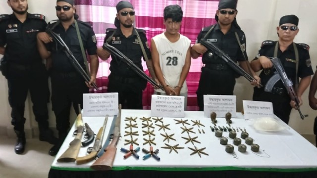 RAB personnel escort a suspected Rohingya criminal, Shofi, after his arrest in Teknaf on Monday night; weapons, ammunition, and grenades were recovered during the operation.