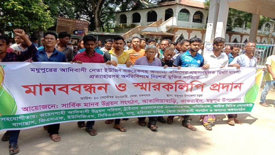 "Garo-Koch community stages protest in Madhupur, demanding the withdrawal of cases and release of 12 detained individuals, including Eugene Nakrek."