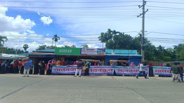 Local residents form a human chain demanding the restoration of Faliyapara Government Primary School polling center in Ukhiya on Saturday morning.