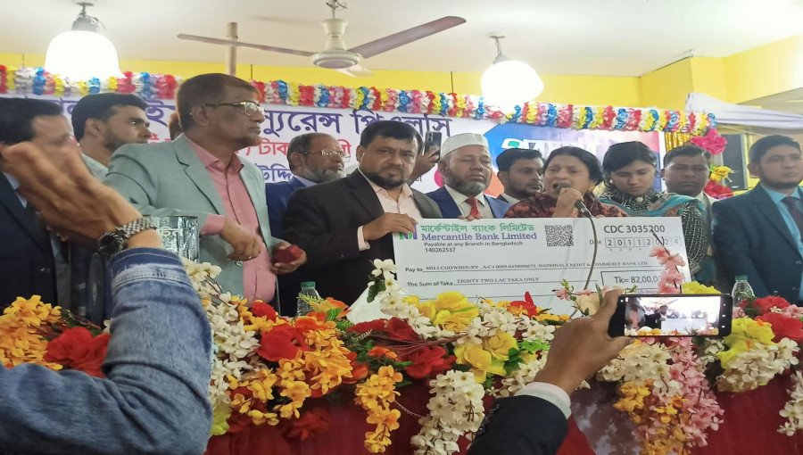 National Life Insurance officials handing over the Tk 10.6 crore insurance claim cheque to beneficiaries during the prize distribution and development meeting in Madhabpur.