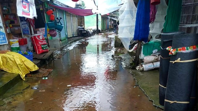 Stagnant rainwater accumulates inside Mirer Hat Bazar in Putiakhali, Jhalokathi, severely disrupting businesses and pedestrian movement.
