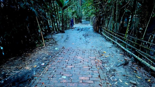 A partially completed brick road in Patuakhali village of Rajapur upazila, Jhalokathi, remains muddy and impassable, causing daily suffering for locals.