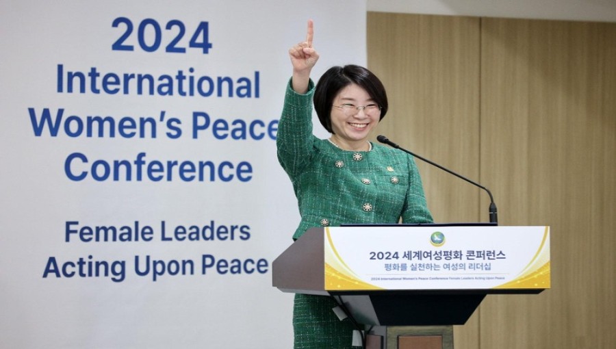 IWPG Chairwoman Hyun Sook Yoon raises her index finger, declaring "We are one" at the 2024 International Women's Peace Conference. Photo: IWPG